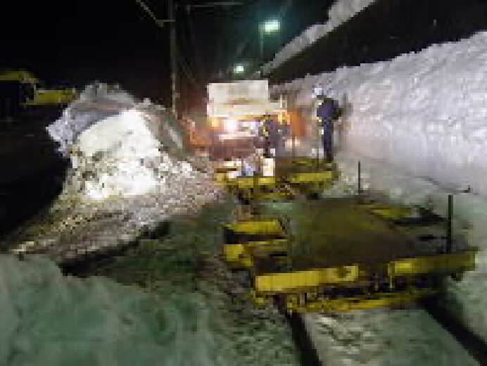 在来鉄道軌道内での搬入作業電車停止時間中(23:00~5:00)の乗り入れ作業のため軌陸車(軌条走行用特殊車)とトロ台車をクレーンにて吊り入れる。